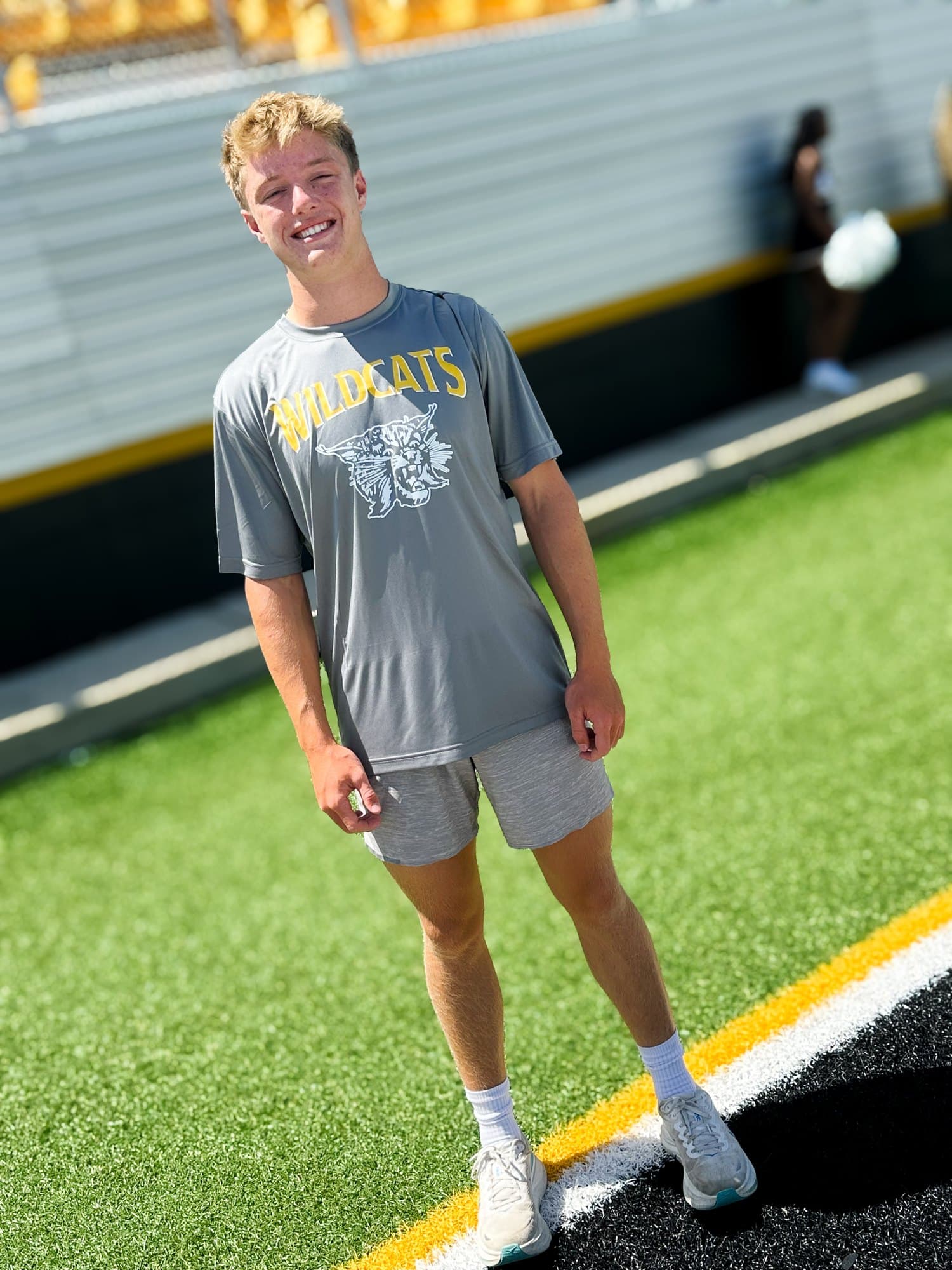 A Valdosta Wildcats fan on the field in a gray Wildcats tee