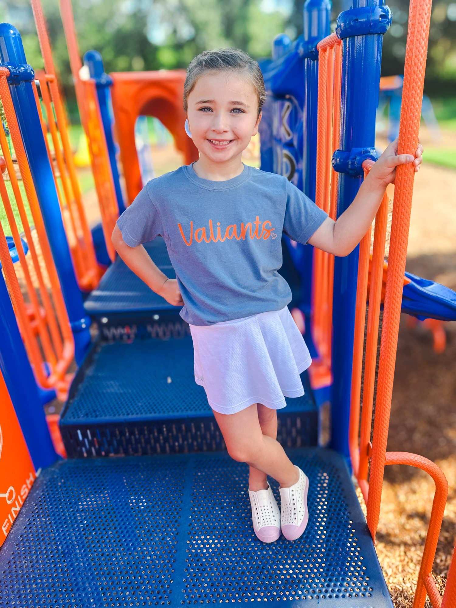 A young Valwood Valiants fan on the playground in a script Valiants tee